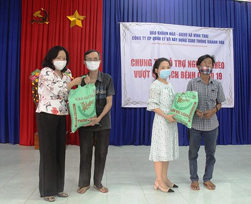 Lãnh đạo Báo Khánh Hòa và lãnh đạo Công ty Cổ phần Quản lý và Xây dựng giao thông Khánh Hòa trao quà cho người dân xã Vĩnh Thái