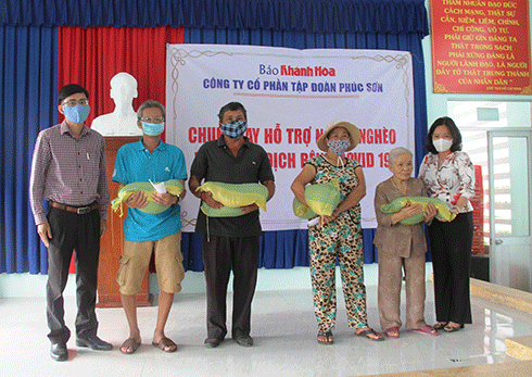 Lãnh đạo Báo Khánh Hòa và lãnh đạo UBND xã Vĩnh Trung trao quà cho các hộ dân địa phương