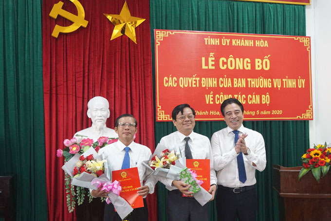 Ông Nguyễn Khắc Toàn trao quyết định và tặng hoa cho ông Trần Ngọc Thanh (bìa trái) và ông Trần Mạnh Dũng