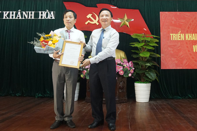 Nguyễn Khắc Định trao quyết định và tặng hoa chúc mừng ông Hà Quốc Trị.