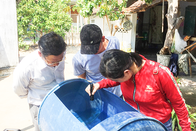 Kiểm tra dụng cụ chứa nước của hộ dân ở huyện Vạn Ninh. 