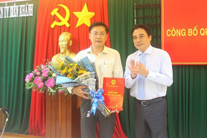 Ông Nguyễn Khắc Toàn trao quyết định và tặng hoa chúc mừng ông Trần Văn Kính.