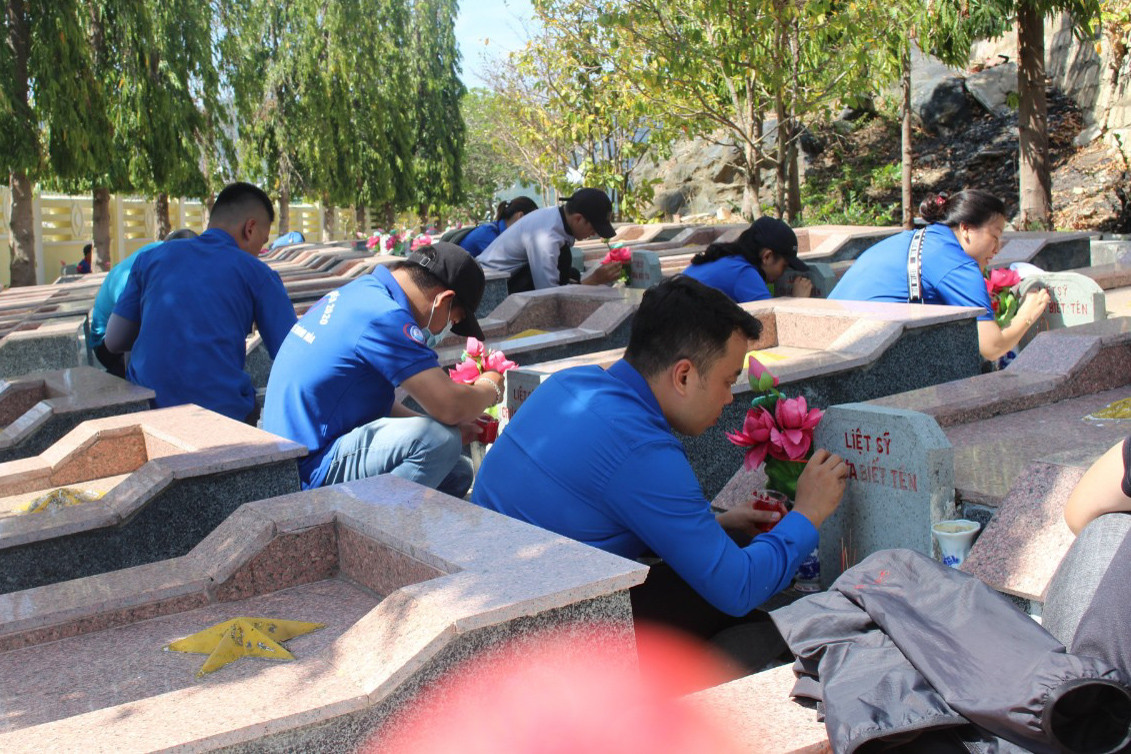 Các đoàn viên, thanh niên sơn thông tin bia liệt sĩ tại Nghĩa trang liệt sĩ Hòn Dung