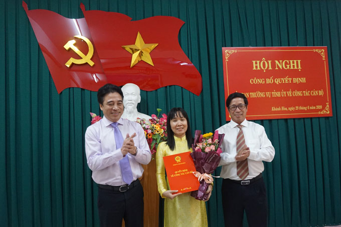 Ông Nguyễn Khắc Toàn (bìa trái) trao quyết định, lãnh đạo Đảng ủy Khối các cơ quan tỉnh tặng hoa chúc mừng bà Nguyễn Thị Bích Liên.