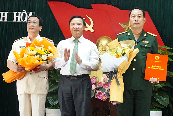Ông Nguyễn Khắc Định trao quyết định và tặng hoa chúc mừng Đại tá Bùi Đại Thắng và Đại tá Đào Xuân Lân.
