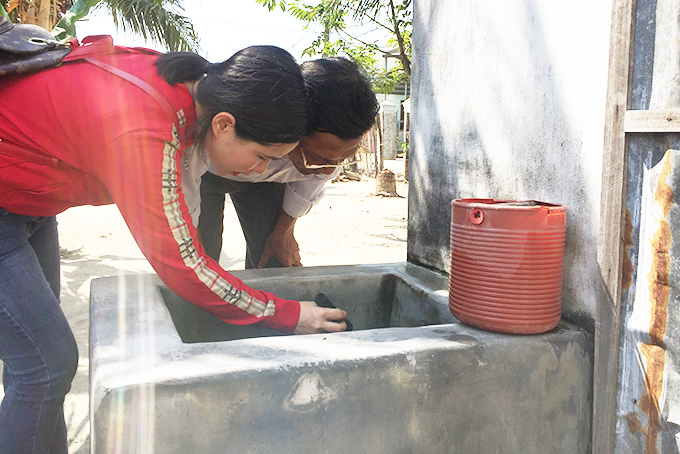 Cán bộ y tế kiểm tra dụng cụ chứa nước ở nhà người dân huyện Vạn Ninh.