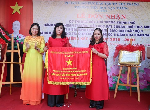 Bà Trần Thu Mai – Giám đốc Sở Nội vụ Khánh Hòa trao cờ thi đua của Chính phủ cho nhà trường. 