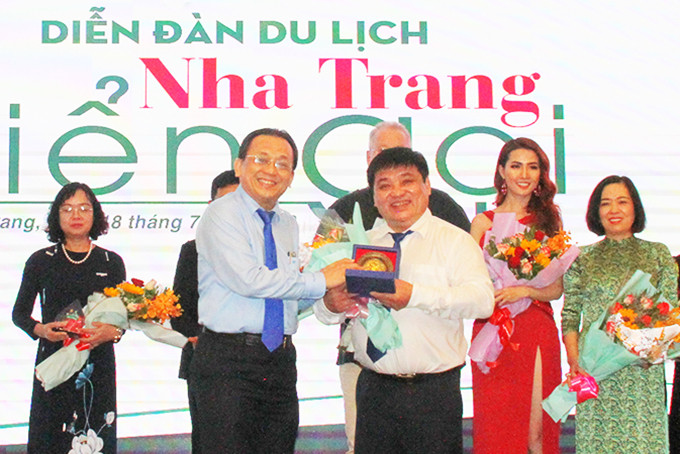 Đồng chí Lê Hữu Hoàng - Phó Chủ tịch UBND tỉnh tặng quà cho Báo Tuổi Trẻ  tại Diễn đàn du lịch Ấn tượng Việt Nam - Nha Trang biển gọi. 