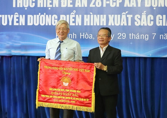 ại diện Trung ương Hội Khuyến học Việt Nam (bìa phải) trao cờ thi đua cho Hội Khuyến học tỉnh Khánh Hòa. 