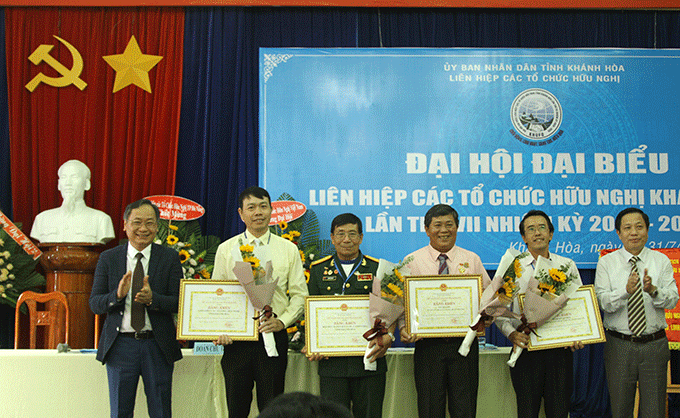 Ông Hà Quốc Trị (bìa phải) và ông Nguyễn Đắc Tài (bìa trái) trao bằng khen của UBND tỉnh Khánh Hòa cho các tập thể, cá nhân.