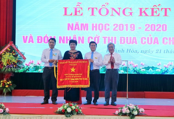 Ông Lê Xuân Thân trao cờ thi đua của Chính phủ cho nhà trường. 