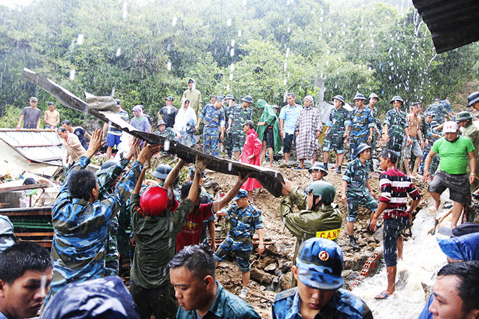 Cán bộ, học viên, chiến sĩ Trường Sĩ quan Không quân giúp người dân xã Phước Đồng khắc phục hậu quả cơn bão số 8 vào tháng 11-2018.
