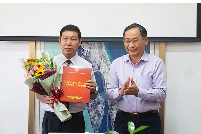 Ông Nguyễn Đắc Tài trao quyết định và tặng hoa chúc mừng.