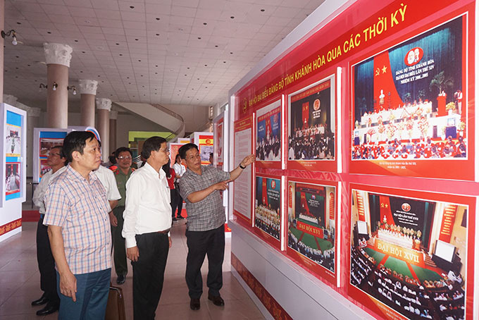 Ông Nguyễn Tấn Tuân, ông Hà Quốc Trị cùng các vị trong Ban Thường vụ Tỉnh ủy kiểm tra khu vực triển lãm ảnh.