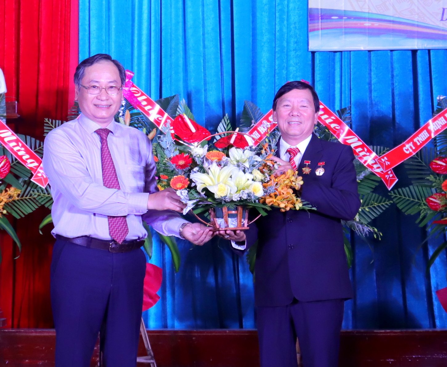 Ông Nguyễn Đắc Tài tặng hoa chúc mừng nhà trường tại lễ khai giảng