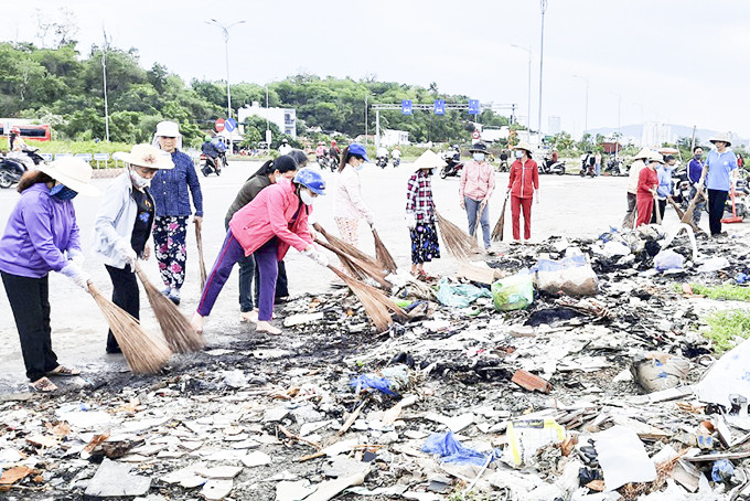 Hội Phụ nữ xã Vĩnh Thái (TP. Nha Trang) dọn vệ sinh, tạo cảnh quan trên đường Võ Nguyên Giáp. Ảnh: M.Thiết