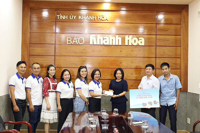 Bà Thái Thị Lệ Hằng – Phó Tổng Biên tập Báo Khánh Hòa (thứ 3 từ phải qua) tiếp nhận kinh phí ủng hộ của nhóm cựu học sinh Trường THPT Lý Tự Trọng. 