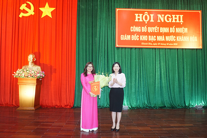 Bà Trần Thị Huệ trao quyết định và tặng hoa chúc mừng bà Phạm Thị Hồ Lan.