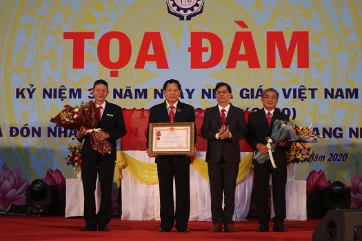 Ông Nguyễn Tấn Tuân trao Huân chương Lao động hạng Nhất của Chủ tịch Nước cho nhà trường. 