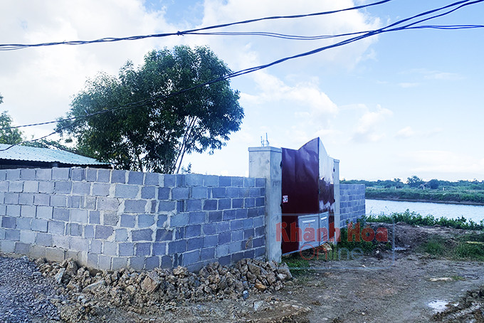 Một đìa tôm mới được san lấp, xây tường bao quanh và ngôi nhà nhỏ ở phía trong.