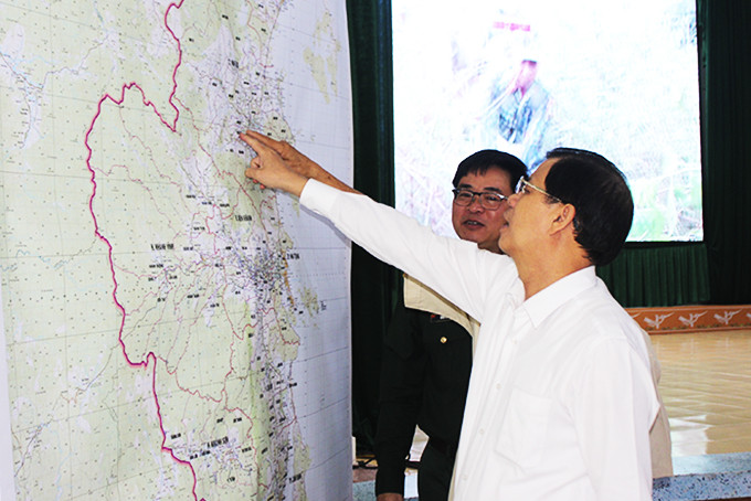 zzĐồng chí Nguyễn Tấn Tuân cùng các đại biểu xem bản đồ tìm kiếm, quy hoạch mộ liệt sĩ.