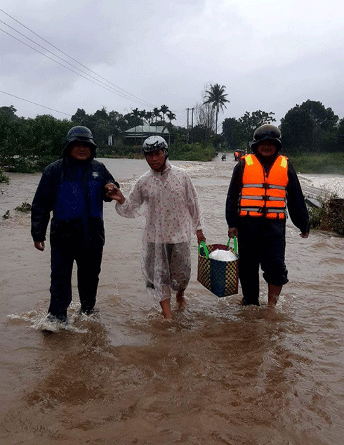 Lực lượng của UBND xã Sơn Lâm hỗ trợ người dân qua cầu tràn Ko Róa vào sáng 29-11 khi mực nước còn thấp