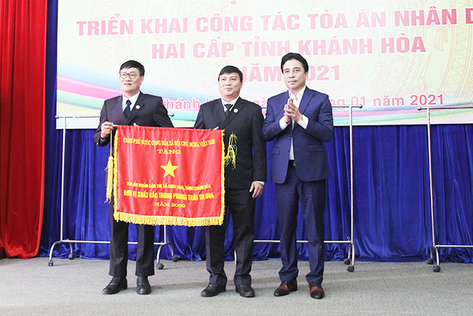 Đồng chí Nguyễn Khắc Toàn trao cờ thi đua của Chính phủ  cho Tòa án nhân dân thị xã Ninh Hòa.
