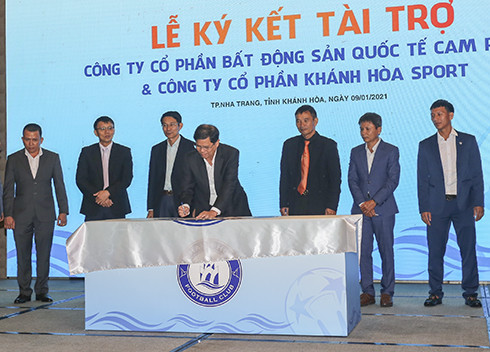 Ông Nguyễn Tấn Tuân ký tên lên cờ truyền thống đội.