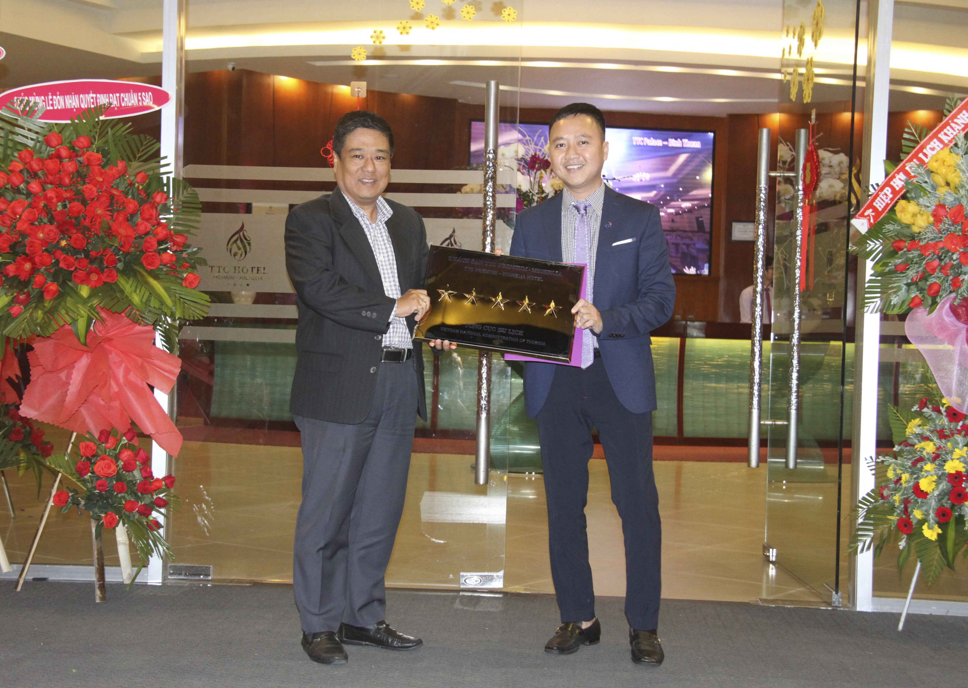 Thay mặt Tổng cục Du lịch, ông Trần Việt Trung - Giám đốc Sở Du lịch Khánh Hòa (bên trái) trao chứng nhận 5 sao cho khách sạn TTC Premium- Michelia