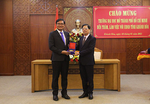 Ông Nguyễn Tấn Tuân trao quà lưu niệm tặng Trường Đại học Mở TP. Hồ Chí Minh.