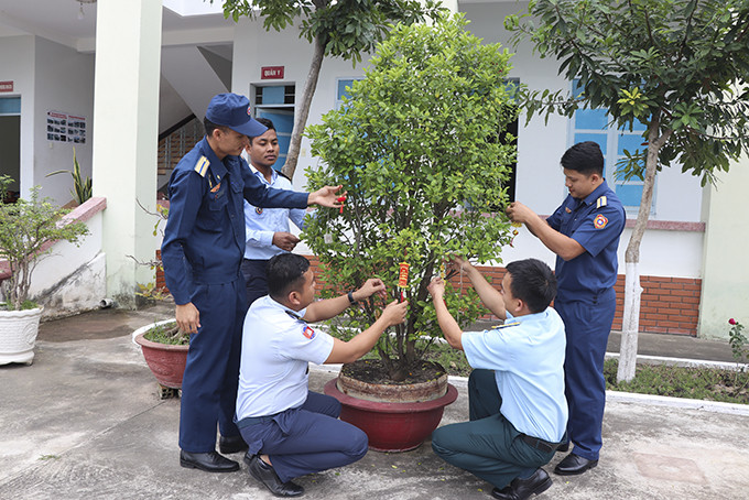 Các học viên cùng lãnh đạo Tiểu đoàn Quốc tế, Trường Sĩ quan Không quân  trang trí đón Tết Việt tại đơn vị.  