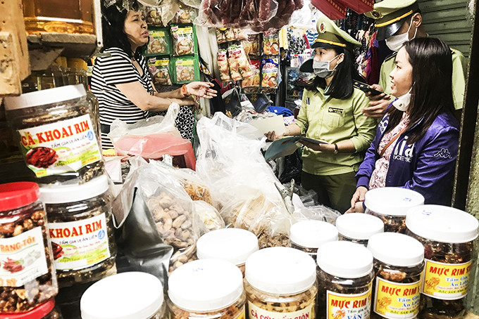 Lực lượng quản lý thị trường kiểm tra mặt hàng thực phẩm tại chợ Xóm Mới.