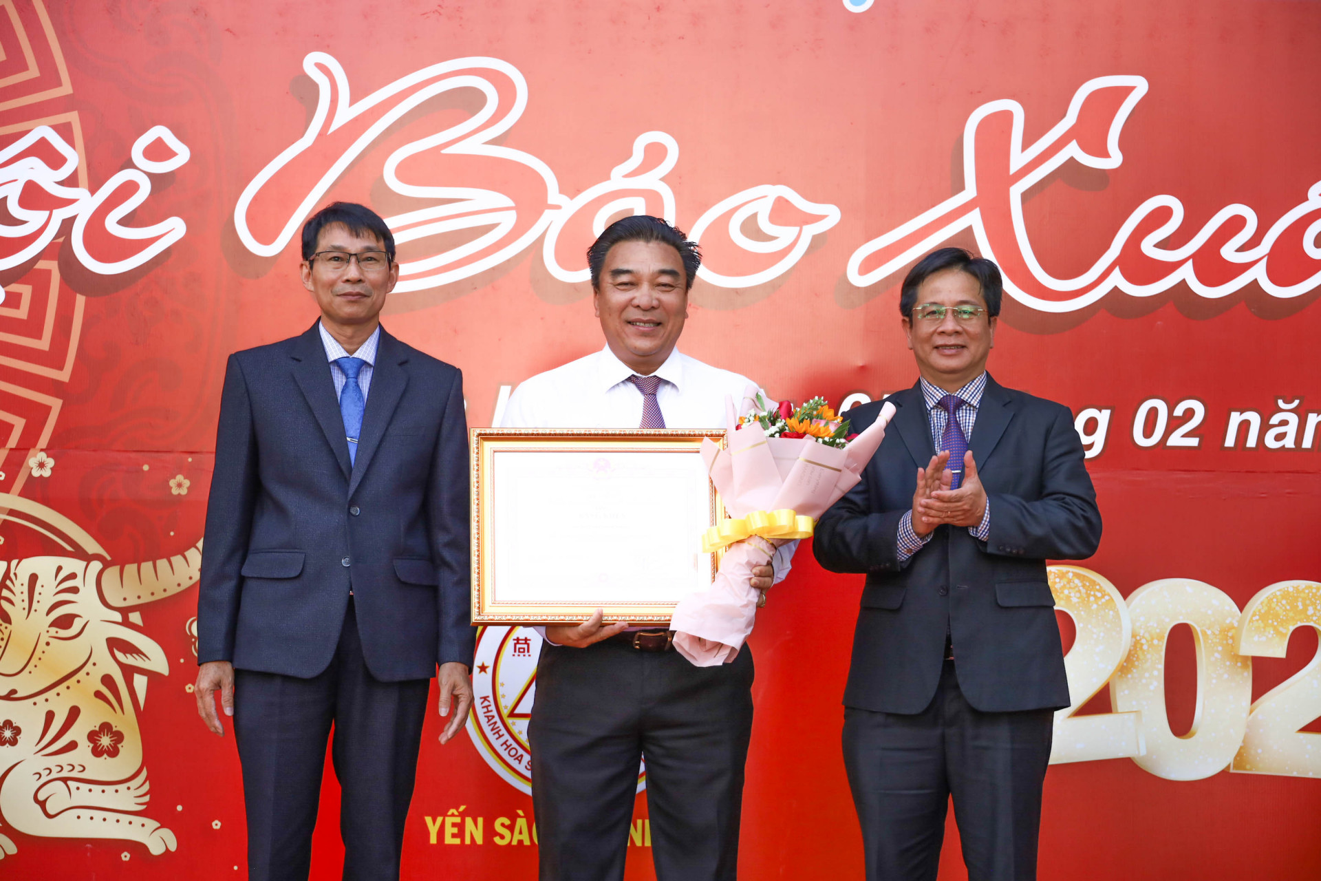 Ông Hồ Văn Mừng (bên phải) và ông Đinh Văn Thiệu trao bằng khen của Thủ tướng Chính phủ và hoa chúc mừng đại diện lãnh đạo Hội Nhà báo tỉnh Khánh Hòa. 