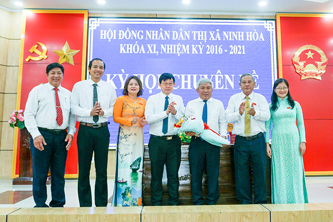 Ông Nguyễn Minh Thư (thứ 3 từ phải qua) nhận hoa chúc mừng của lãnh đạo thị xã Ninh Hòa.