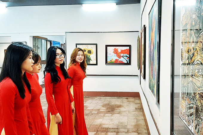 Sinh viên Trường Đại học Khánh Hòa xem các tác phẩm trưng bày tại triển lãm.