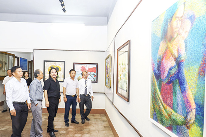 Các đại biểu xem tác phẩm giới thiệu tại triển lãm.