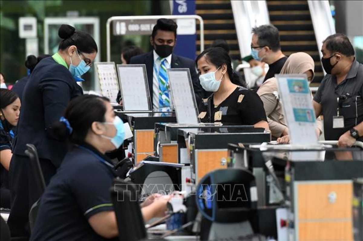 Hành khách làm thủ tục tại sân bay quốc tế Changi ở Singapore. Ảnh: AFP/TTXVN