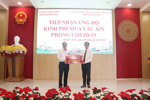 Ông Nguyễn Tấn Tuân tiếp nhận tượng trưng số kinh phí ủng hộ mua vắc xin phòng Covid-19 từ đại diện Agribank Khánh Hòa