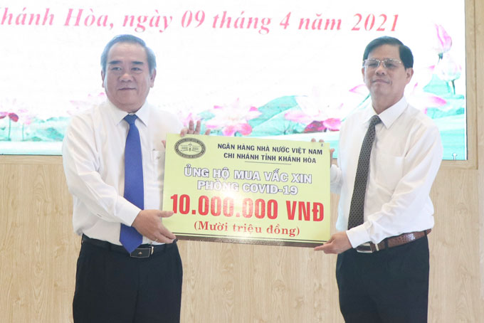 Ông Nguyễn Tấn Tuân tiếp nhận tượng trưng số kinh phí ủng hộ mua vắc xin phòng Covid-19 từ đại diện Ngân hàng Nhà nước Chi nhánh Khánh Hòa.
