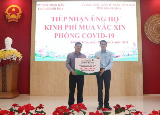 Ông Đinh Văn Thiệu tiếp nhận tượng trưng số kinh phí ủng hộ mua vắc xin phòng Covid-19 từ Vietcombank Chi nhánh Nha Trang.