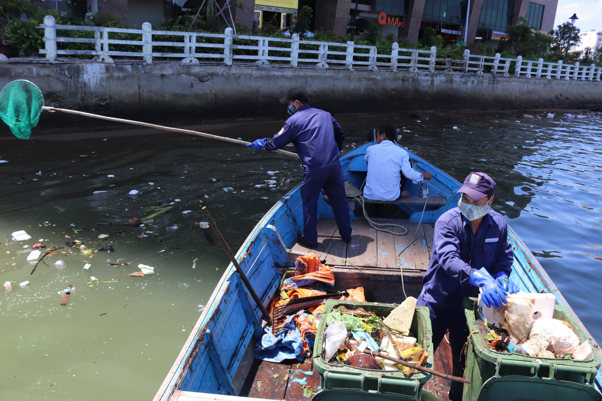 Công nhân thu gom rác dưới chân cầu Trần Phú.