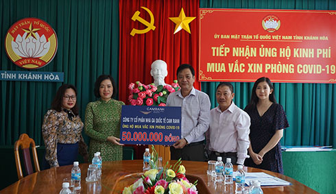 Bà Lê Thị Hồng Minh - Tổng Giám đốc Công ty Cổ phần Nhà ga Quốc tế Cam Ranh (thứ 2 từ trái qua) trao tiền ủng hộ tỉnh mua vắc xin phòng Covid-19
