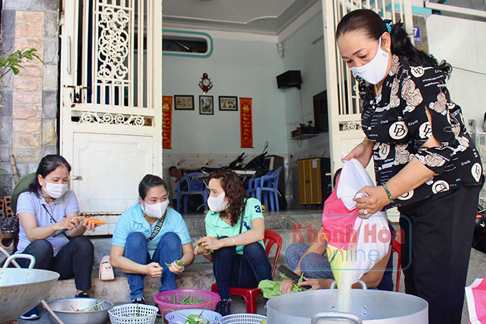 Bà Nguyễn Thị Ngọc Ân (bìa phải) đang chuẩn bị nguyên liệu nấu cơm từ thiện.