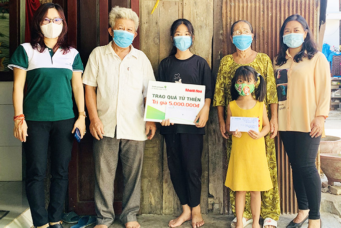 Đại diện Báo Khánh Hòa và Vietcombank Nha Trang  trao tiền ủng hộ cho gia đình 3 chị em.