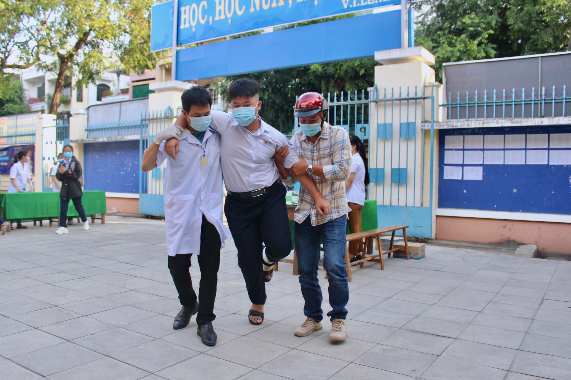 Nhân viên y tế hỗ trợ thí sinh bị đau chân vào phòng thi tại hội đồng thi Trường THPT Lý Tự Trọng (TP. Nha Trang)