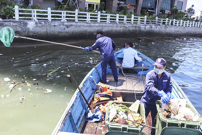 Công nhân thu gom rác thải trên biển Nha Trang.
