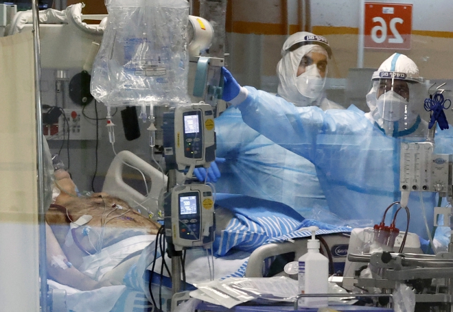 Nhân viên y tế điều trị cho bệnh nhân COVID-19 tại bệnh viện ở Ramat Gan, Israel. Ảnh: AFP/ TTXVN