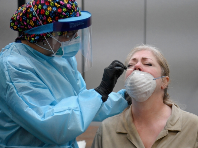 Nhân viên y tế lấy mẫu xét nghiệm COVID-19 cho người dân tại New York, Mỹ. Ảnh: AFP/TTXVN