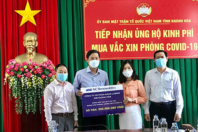 Đại diện Công ty Cổ phần Năng lượng AMI Khánh Hòa (thứ 2 từ trái qua) trao tượng trưng kinh phí hỗ trợ mua vắc xin