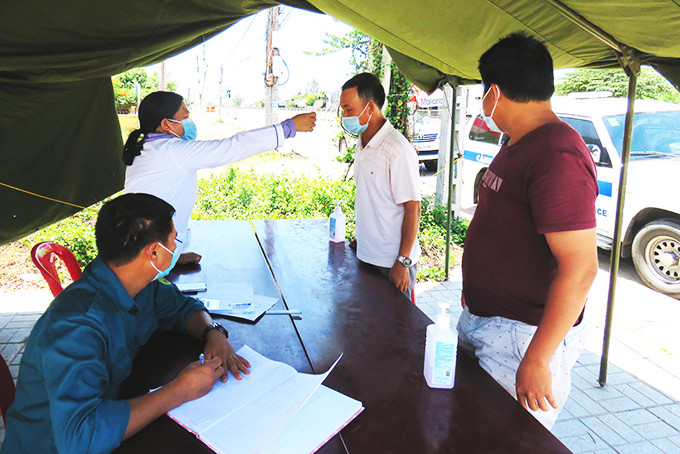 Lực lượng chốt kiểm soát liên ngành phòng, chống dịch Covid-19 tại xã Vạn Thọ (huyện Vạn Ninh)  đo thân nhiệt cho tài xế, người dân.